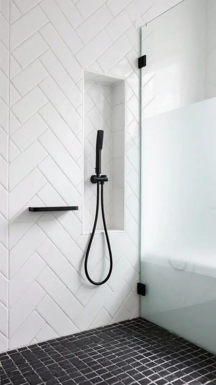 Detail shot focused on pattern and precision: tight herringbone layout of white matte subway tiles on feature wall, narrow vertical niche aligned exactly with herringbone joints; ultra-thin matte black fixtures (lean bar hand shower, minimalist mixer) against crisp white; black porcelain mosaic floor visible at bottom edge; single glass panel with black bracket; bright, even lighting for high-contrast clarity.