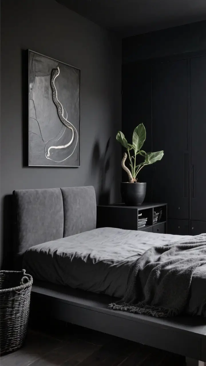 Medium shot: Minimalist yet cozy black bedroom—low platform bed with simple lines and soft charcoal upholstery, one large-scale art piece above the headboard, closed black storage dresser and black baskets to hide clutter, a single snake plant in a matte black pot; a tactile throw on the bed to soften the look; composition is edited, with negative space and calm, even lighting.