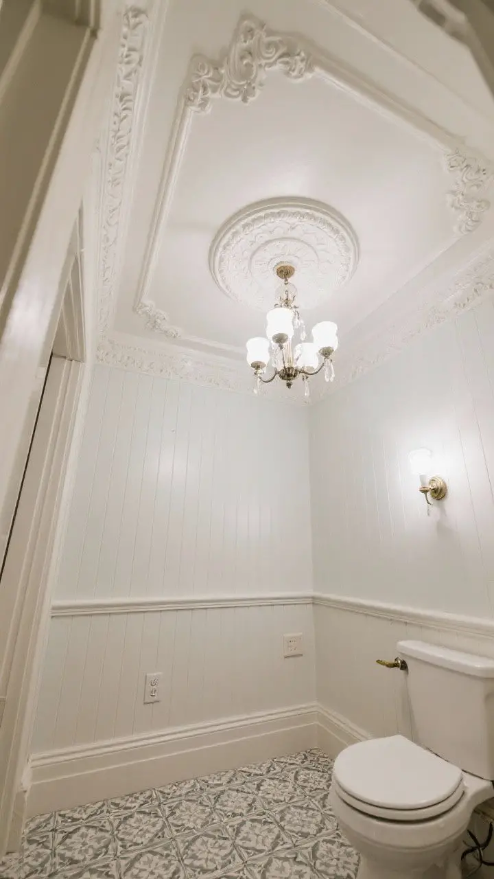 Wide upward angle of a bathroom ceiling showcasing substantial crown molding, a classic ceiling medallion, and a petite chandelier rated for damp locations; tall-profile baseboards ground patterned tile below; a painted beadboard ceiling adds charm; balanced ambient light ensures crisp definition of moldings while maintaining a cohesive period feel; wiring implied safe on a GFCI circuit.